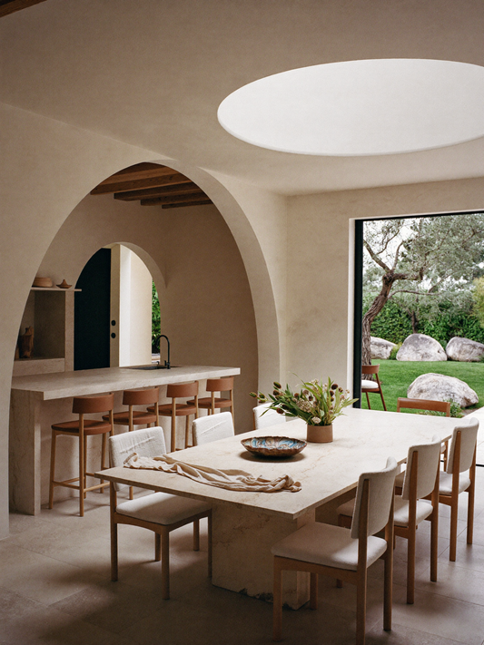 Whole apartment furnished with a coherent material language and varied furniture rather than matching sets
